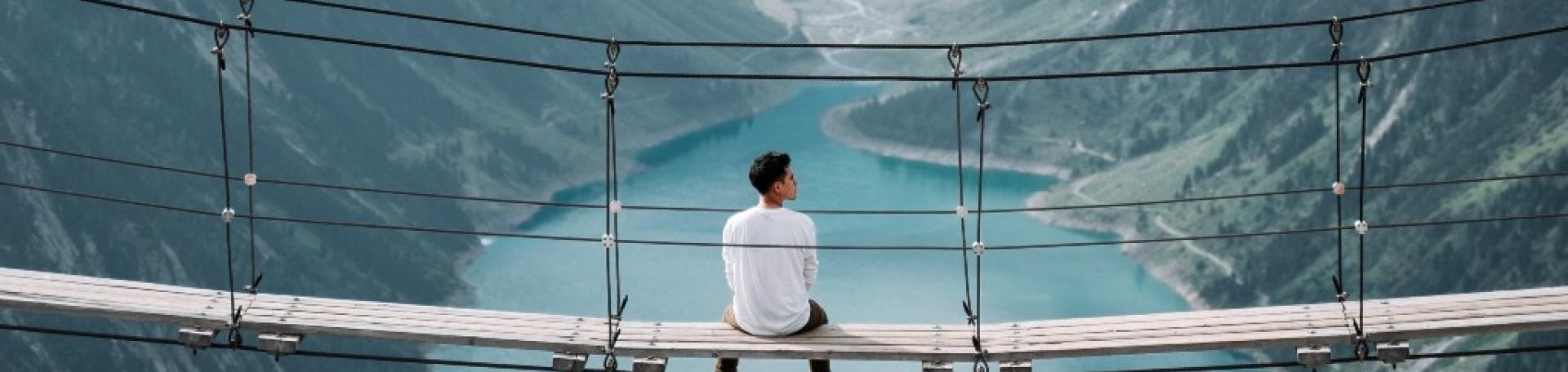 A man sat along on a bridge